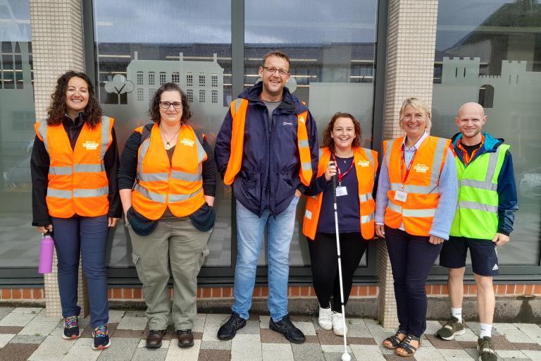 A group of walk leaders standing dressed in high visibility jackets