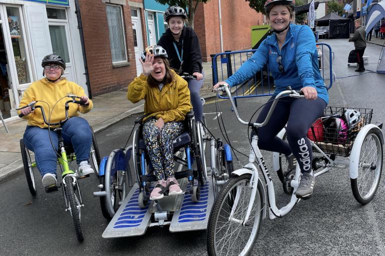 A group of young adults outdoors on adapted bikes