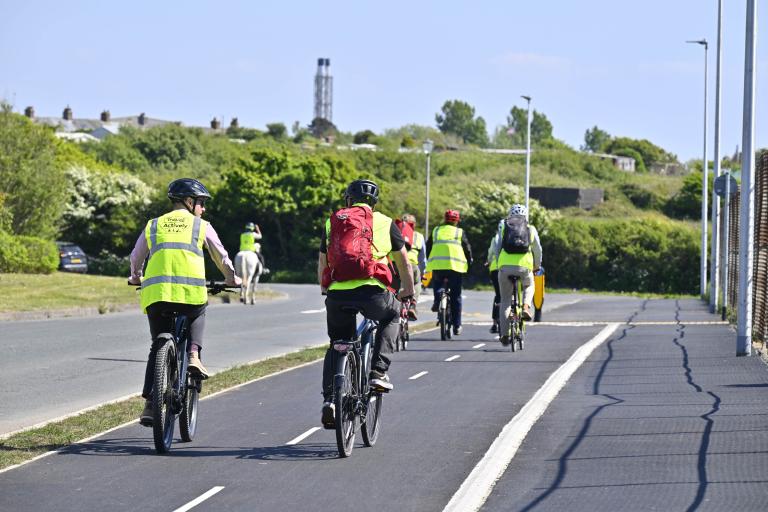 A group of cyclists using the new route built in the pavement space, separating them from motorists on West Shore Road