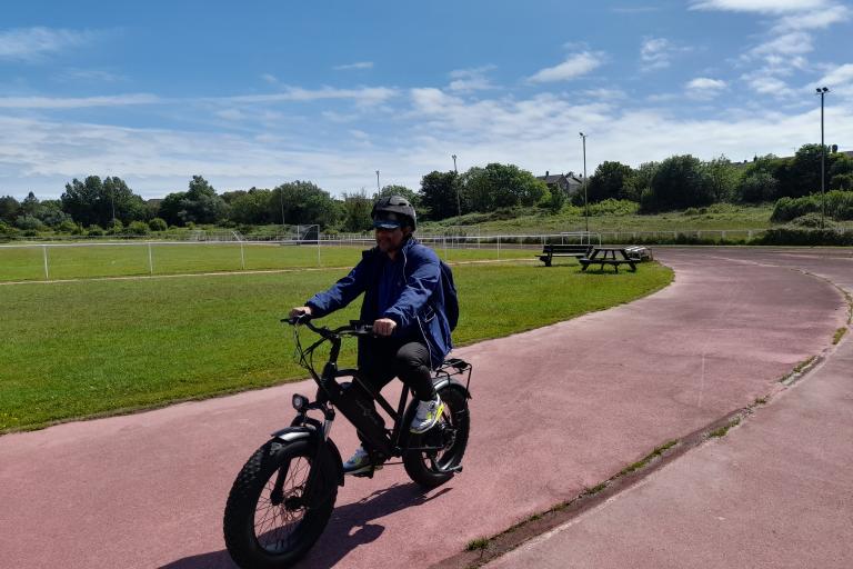 A male riding an e-bike on a track