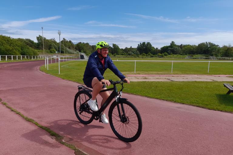 A male riding an e-bike on a track
