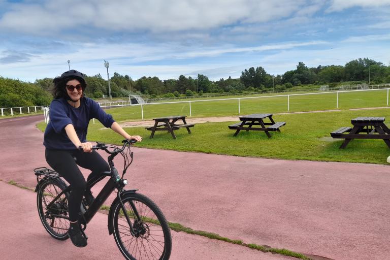 A lady riding an e-bike on a cycle track
