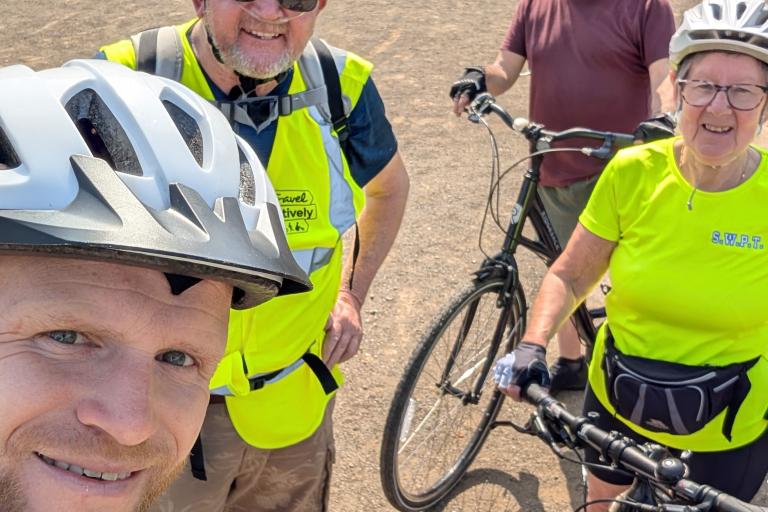a group of cyclists wearing high vis stood smiling at the camera