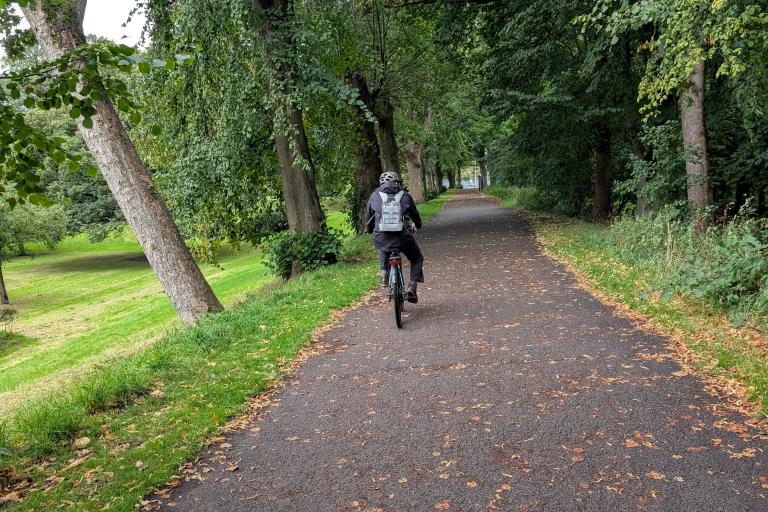 a man riding a bike on a path through trees