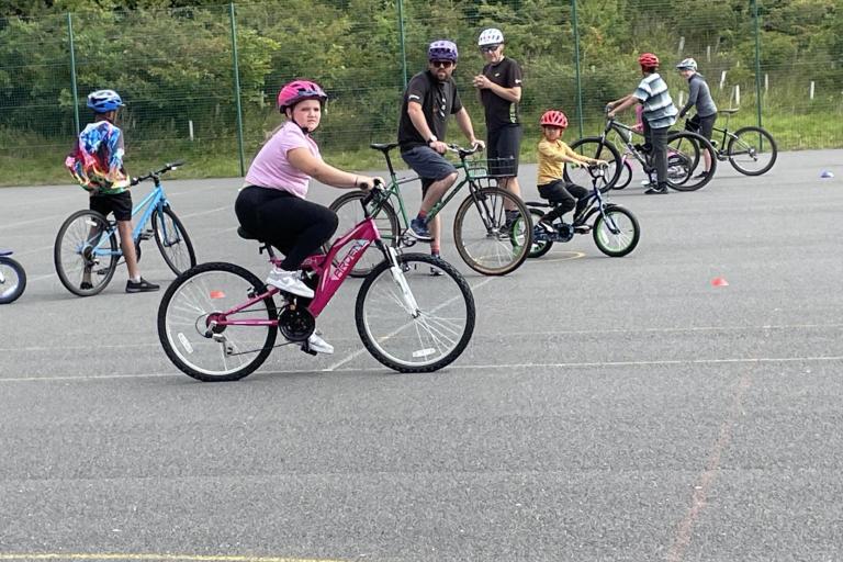 a group of young children learning to ride bikes