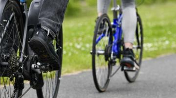 Two cyclists cycling down a path