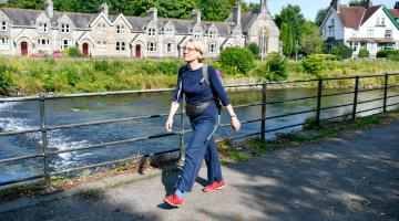Woman walking on a path next to a river