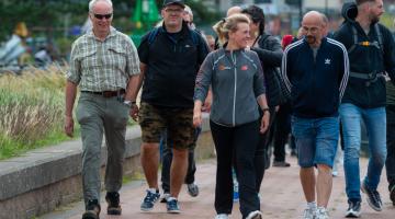 A group of adults walking outdoors in Barrow along the channel