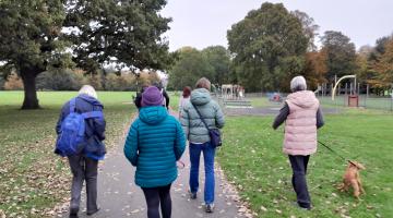 A group of adults walking outdoors in a park in Carlisle