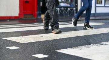 Two pedestrians walking across a zebra crossing