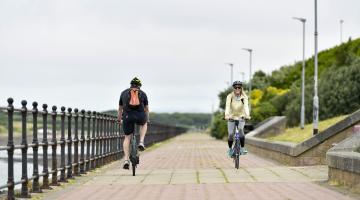 two people cycling along the channelside in Barrow
