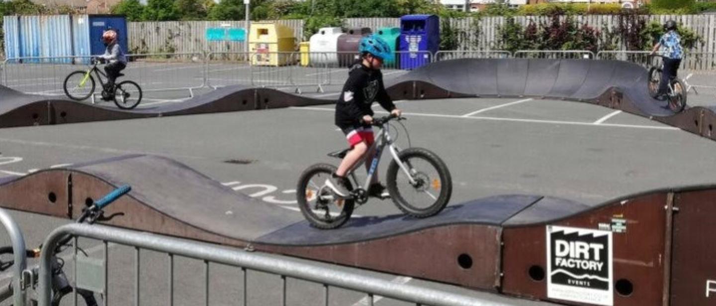 Child on a bike riding on a pump track